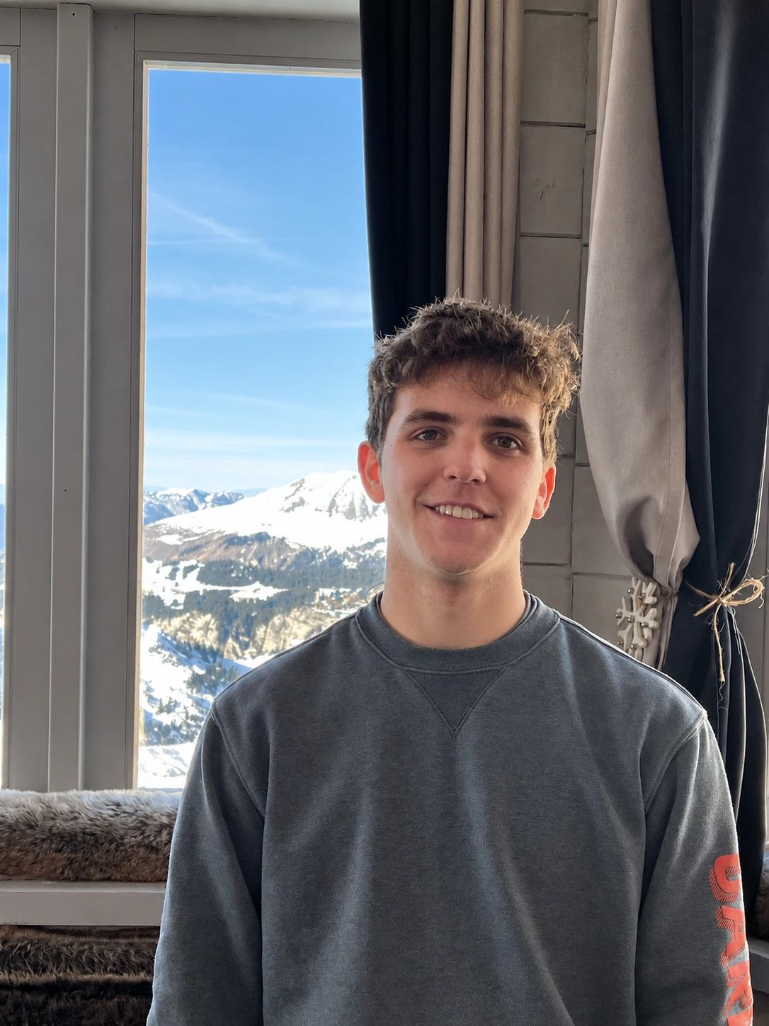 Ben, the founder of UniTracks, beside a mountain-view window